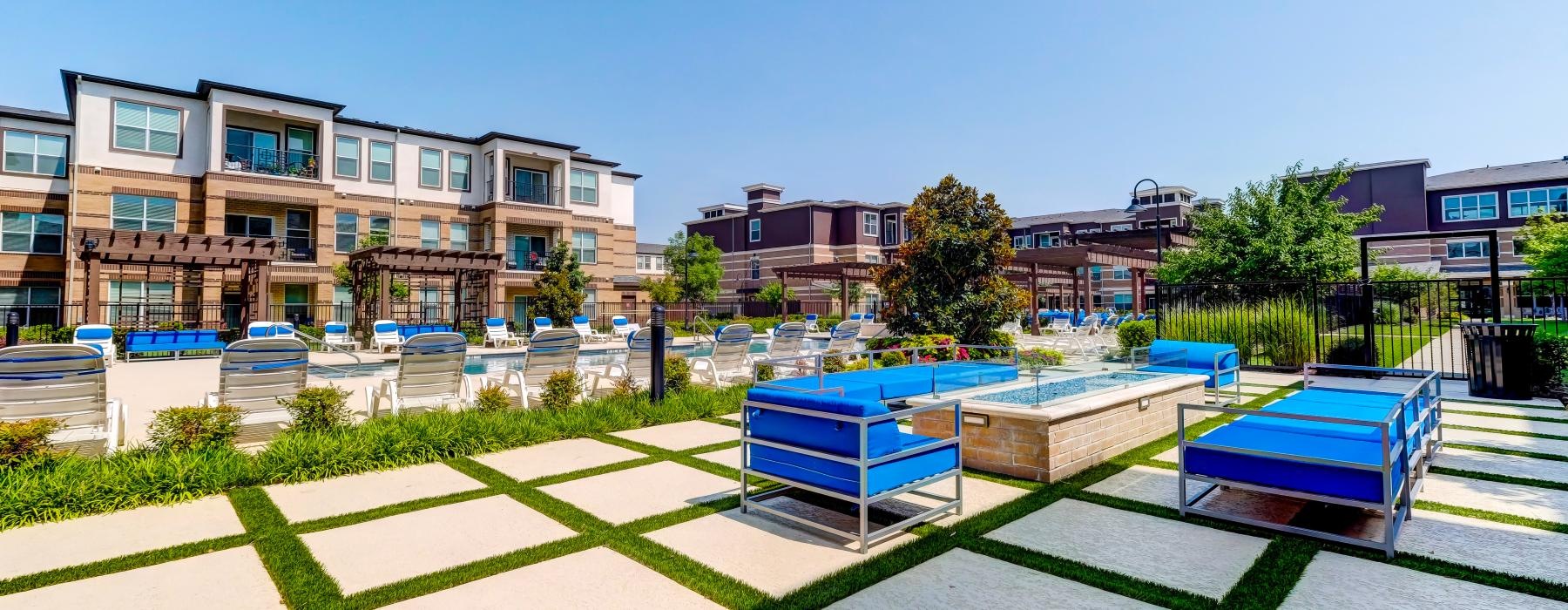 a courtyard with a few pools and buildings in the background