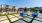 a courtyard with a few pools and buildings in the background